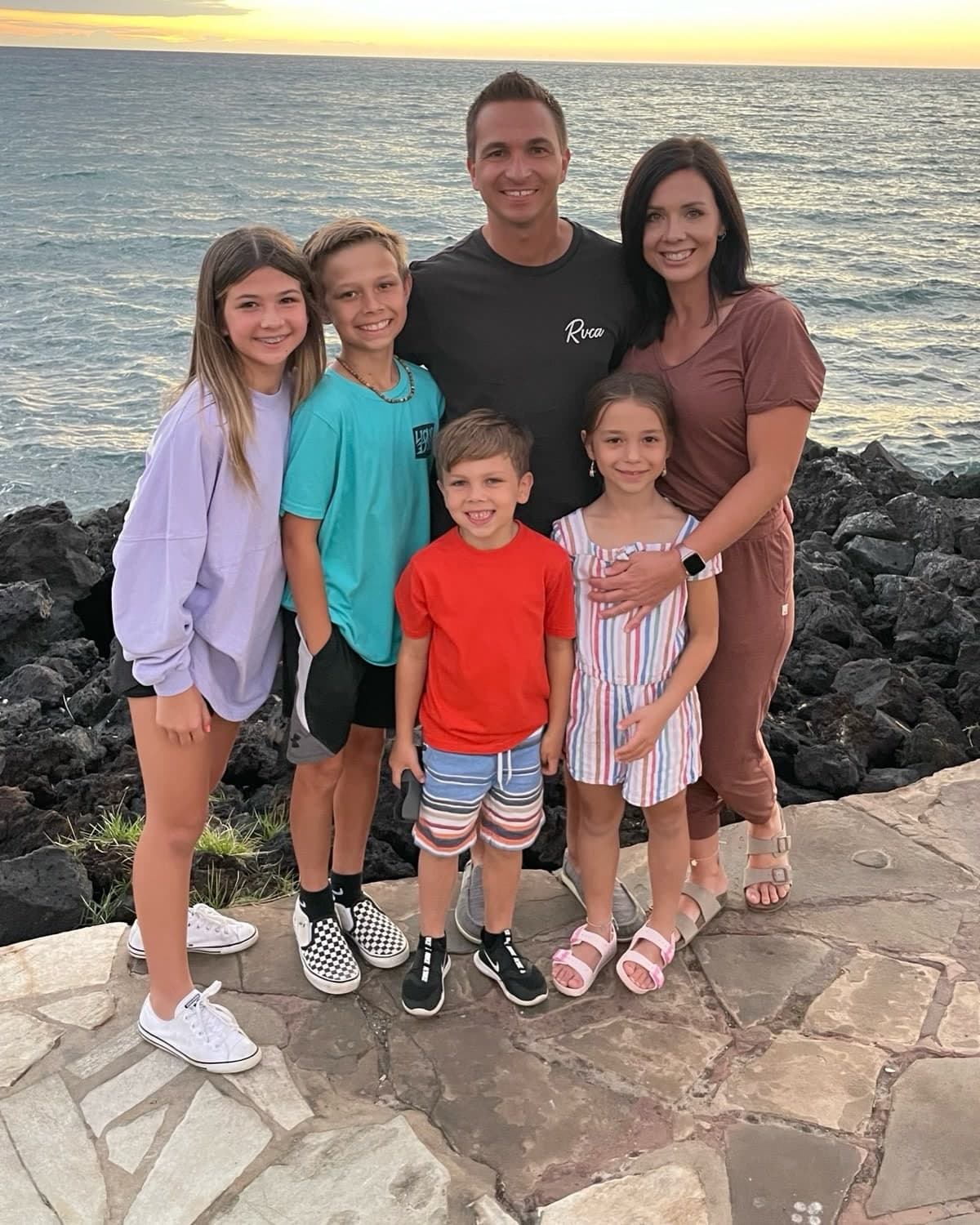 Tom Foote with his family by the ocean at sunset